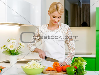 Smiling young woman preparing vegetarian salad