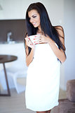Smiling happy woman drinking a cup of coffee