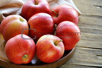 ripe red apples autumn harvest on a wooden plate