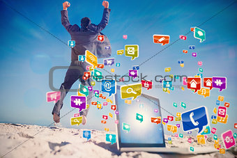 Composite image of victorious businessman jumping leaving his laptop