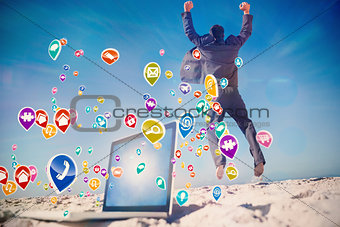 Composite image of victorious businessman jumping leaving his laptop
