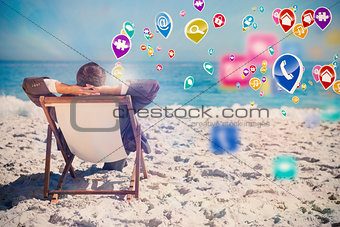 Composite image of young businessman relaxing on his sun lounger