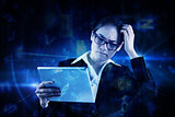 Composite image of thinking businesswoman looking at tablet pc