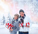 Composite image of festive mature couple holding christmas gifts