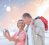 Composite image of couple with shopping bags and tablet
