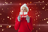 Composite image of happy festive blonde with gift