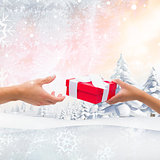 Composite image of couple passing a wrapped gift