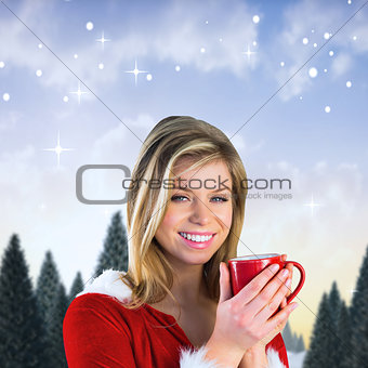 Composite image of pretty santa girl holding mug