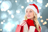 Composite image of happy festive blonde with shopping bag
