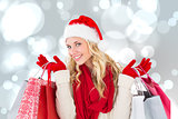 Composite image of happy festive blonde with shopping bags