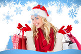 Composite image of festive blonde holding shopping bags