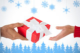 Composite image of couple passing a wrapped gift
