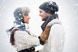 Composite image of attractive young couple in warm clothes hugging