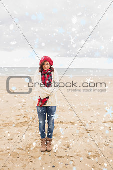 Composite image of pretty woman in stylish warm clothing at beach