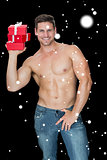 Composite image of muscular man holding pile of presents in blue jeans
