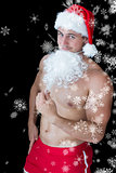 Composite image of smiling muscular man posing in sexy santa outfit with fake beard