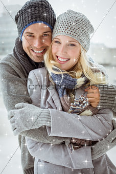 Composite image of cute couple in warm clothing smiling at camera
