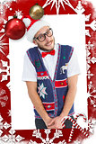 Composite image of geeky hipster in santa hat