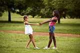 Children playing ring around the rosie in park