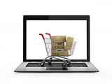 Online shopping concept. Shopping Cart with Boxes over Laptop