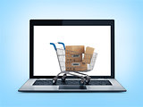 Online shopping concept. Shopping Cart with Boxes over Laptop