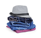 stack of jeans with a hat on an isolated white background
