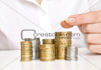 Hand put coins to stack of coins on white background