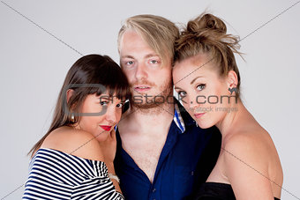 Two Young Female Friends Embracing a Man - 