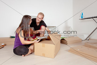 Young Couple Moving, Looking at Old Pictures