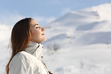 Explorer woman breathing fresh air in winter in a snowy mountain