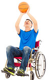 young man sitting on a wheelchair and holding a basketball