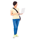 young student girl standing and  holding a laptop 