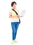 Smiling young woman holding a laptop over white background