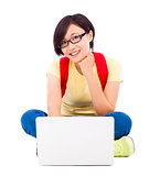 happy young student girl sitting on floor with a laptop