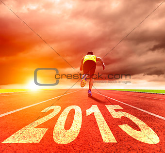 happy new year 2015. young man running with sunrise background