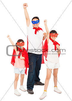 Father and daughters making a superhero pose with red cape