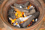burning charcoal in metal rim 