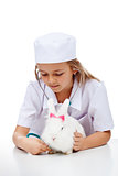 Little girl playing veterinary with her rabbit