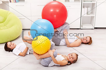 Kids and their mother exercising at home