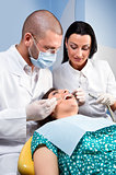 Male dentist with assistant and patient at dental clinic