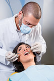 Female patient having her teeth examined by specialist