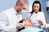 Male dentist with assistant and patient at dental clinic
