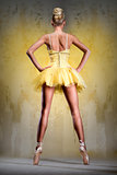 Beautiful ballerina in yellow tutu on point
