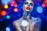 Beautiful woman with creative bright make-up over glowing lights