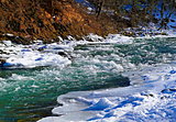 River in winter under snow