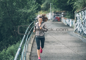 Fitness young woman jogging in the city park
