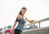 Portrait of fitness young woman stretching outdoors