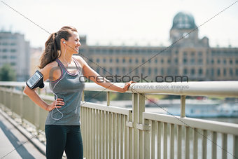 Portrait of fitness young woman in the city looking into distanc
