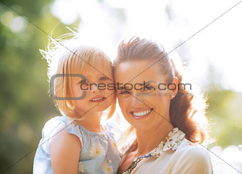 Portrait of happy mother and baby girl outdoors in park