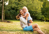 Portrait of happy mother and baby girl hugging in park